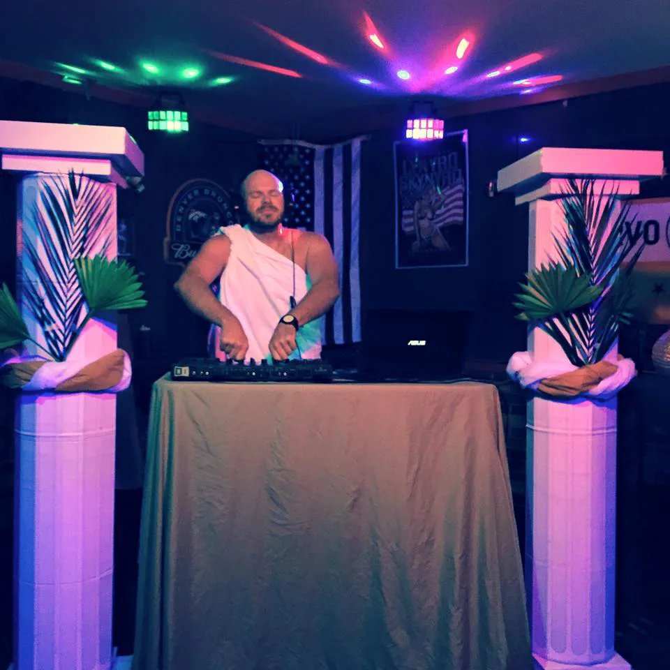 DJ performing at the toga party beside Roman column decor